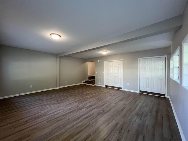 interior space with multiple closets and dark hardwood / wood-style floors