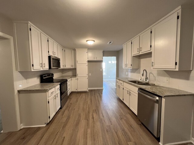 kitchen with white cabinetry, appliances with stainless steel finishes, and dark hardwood / wood-style floors