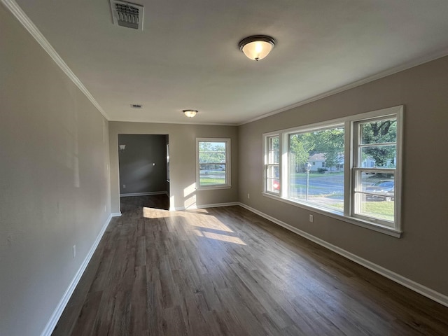 spare room with ornamental molding and dark hardwood / wood-style flooring