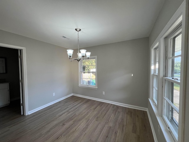 empty room featuring hardwood / wood-style floors and an inviting chandelier