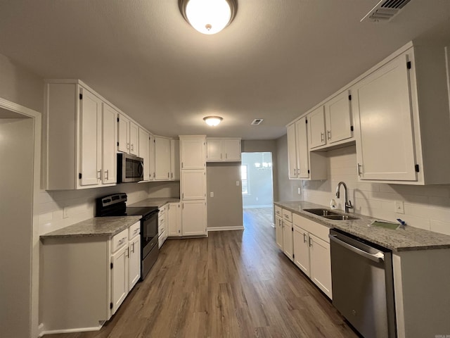 kitchen featuring sink, white cabinetry, backsplash, stainless steel appliances, and stone countertops