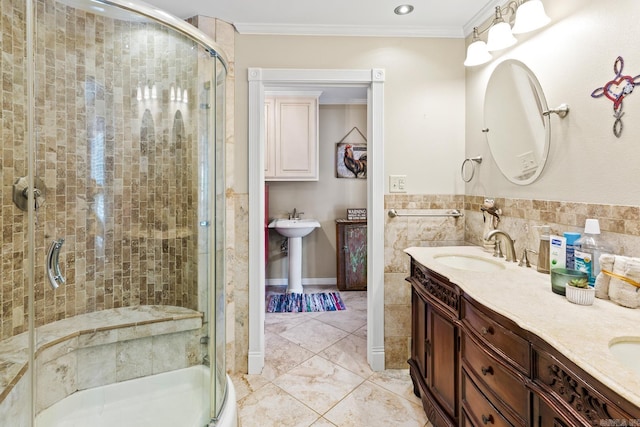 bathroom with a stall shower, a sink, tile walls, and crown molding