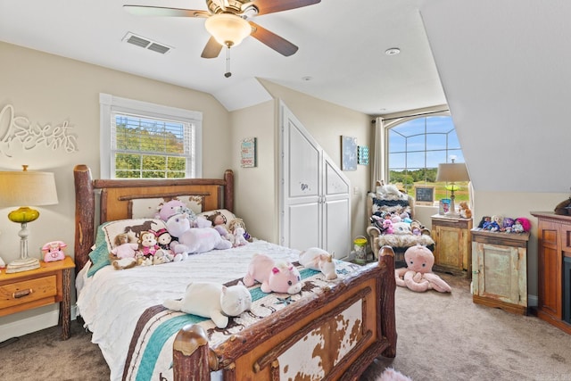 carpeted bedroom with a ceiling fan, lofted ceiling, visible vents, and multiple windows