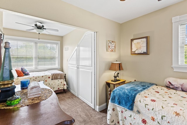 bedroom with carpet floors, multiple windows, baseboards, and a ceiling fan