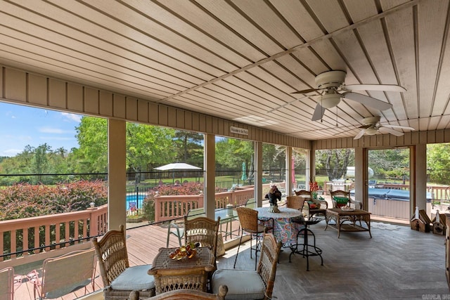 sunroom / solarium featuring a ceiling fan