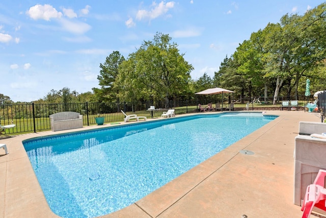 view of swimming pool with a patio area, fence, and a fenced in pool