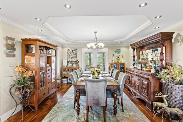 dining room with french doors, a tray ceiling, dark wood-type flooring, and crown molding