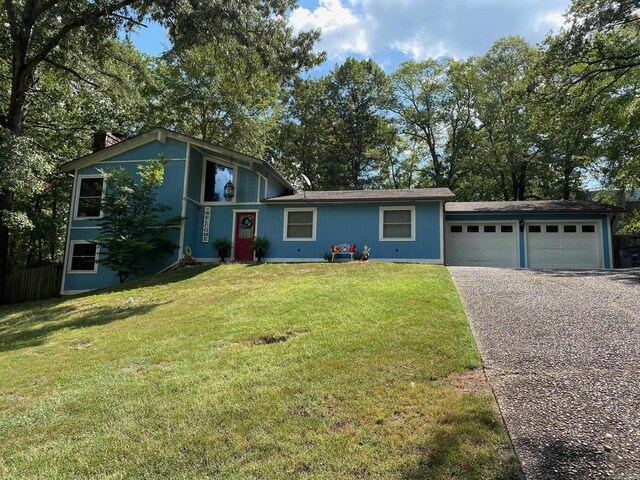 tri-level home with a garage and a front lawn