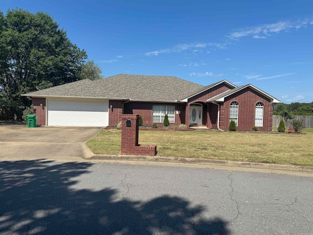 ranch-style house featuring a garage and a front lawn