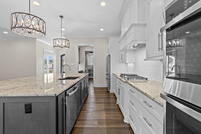 kitchen featuring appliances with stainless steel finishes, sink, a center island with sink, and white cabinets