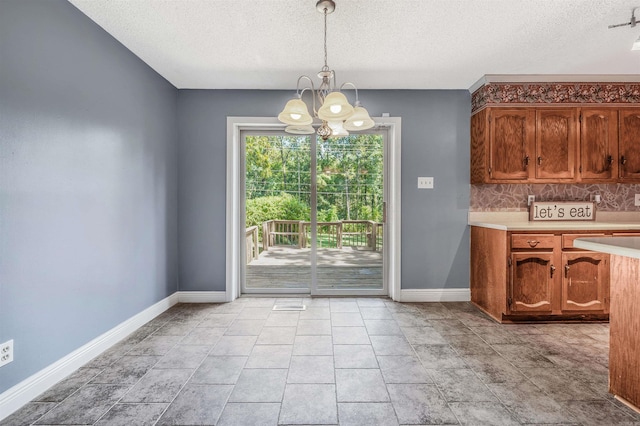 unfurnished dining area featuring a notable chandelier, a textured ceiling, and light tile patterned flooring