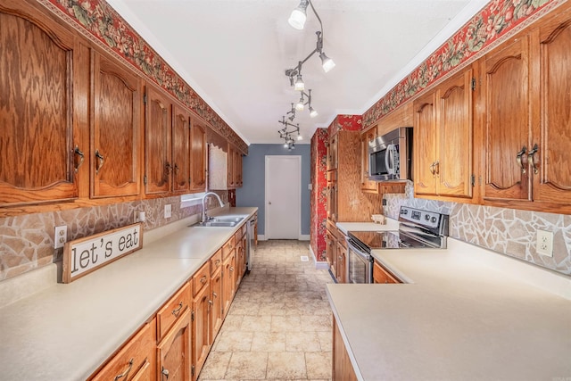 kitchen featuring appliances with stainless steel finishes, sink, decorative backsplash, and track lighting