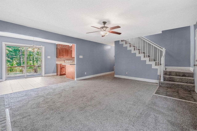 unfurnished living room featuring light carpet and ceiling fan with notable chandelier