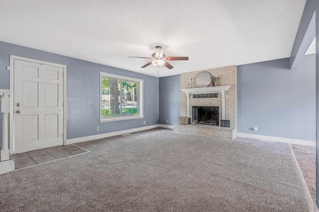 unfurnished living room with brick wall, a fireplace, a textured ceiling, ceiling fan, and light carpet