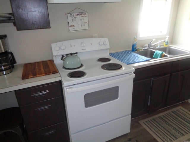 kitchen featuring sink, white range with electric stovetop, and dark brown cabinets