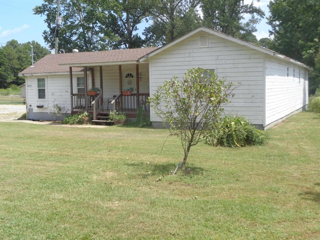 ranch-style house featuring a front lawn and covered porch