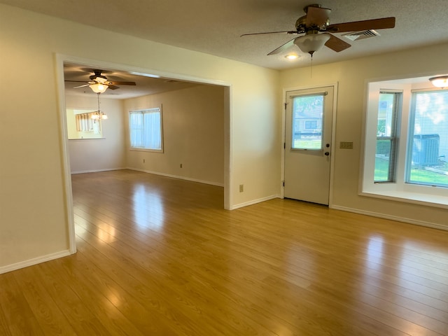 spare room with a wealth of natural light, light wood-type flooring, and ceiling fan