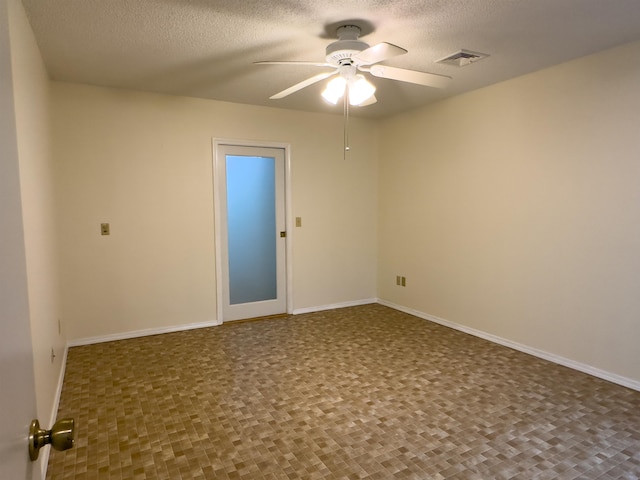 empty room featuring ceiling fan and a textured ceiling