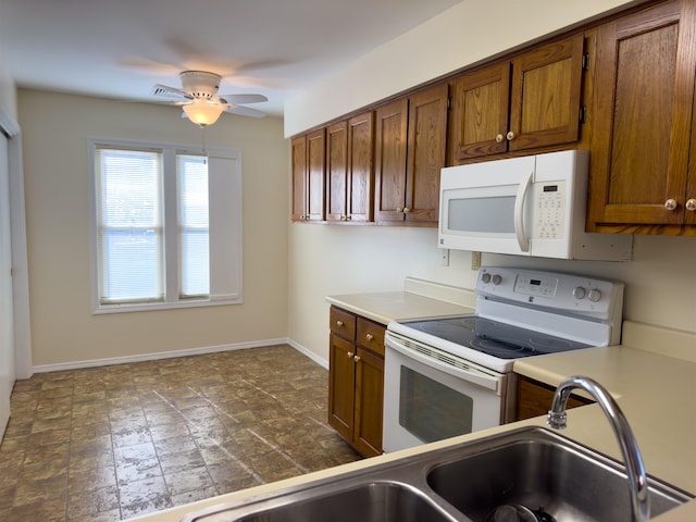 kitchen with dark tile patterned floors, white appliances, and ceiling fan