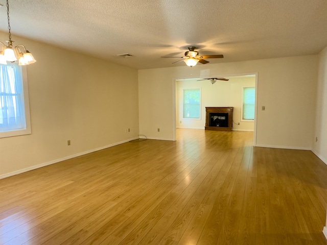 unfurnished living room with hardwood / wood-style flooring, a textured ceiling, and a wealth of natural light