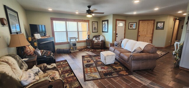 living area featuring recessed lighting, a ceiling fan, baseboards, and wood finished floors