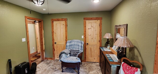 living area with ceiling fan and light tile patterned floors