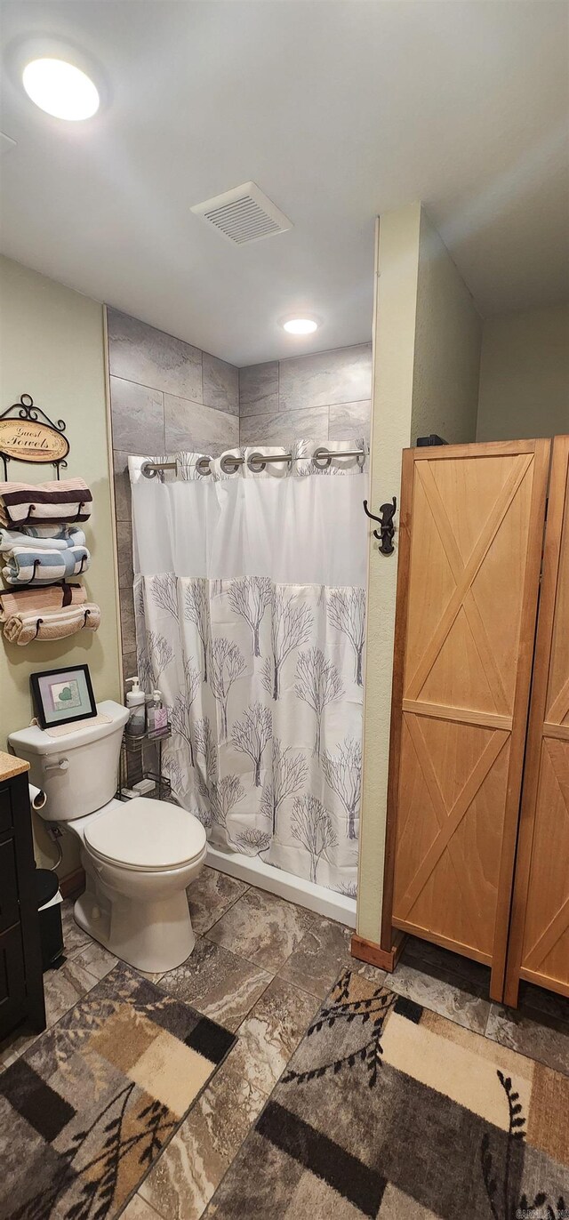 bathroom with tile patterned flooring, vanity, and toilet