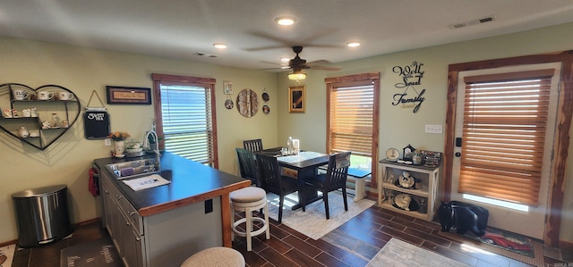 home office featuring ceiling fan, sink, and dark wood-type flooring