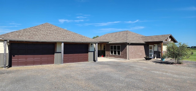 ranch-style house with roof with shingles and an attached garage