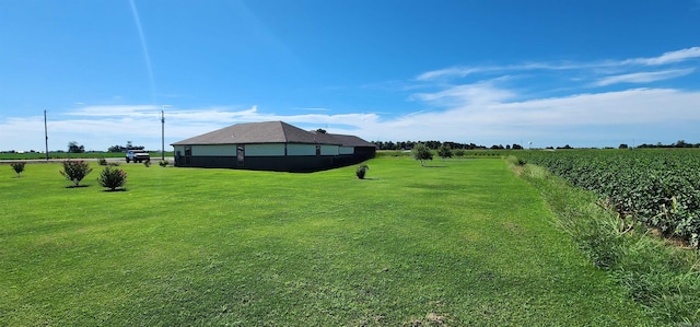 view of green lawn with a rural view