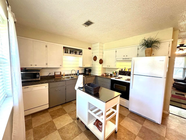 kitchen with sink, white cabinets, a textured ceiling, and white appliances