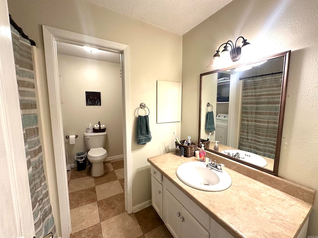 bathroom featuring toilet, vanity, washer / dryer, tile patterned floors, and a textured ceiling