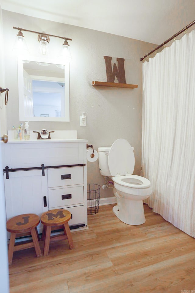 bathroom featuring vanity, hardwood / wood-style floors, and toilet