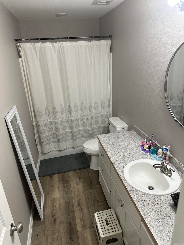 bathroom with toilet, hardwood / wood-style floors, and vanity