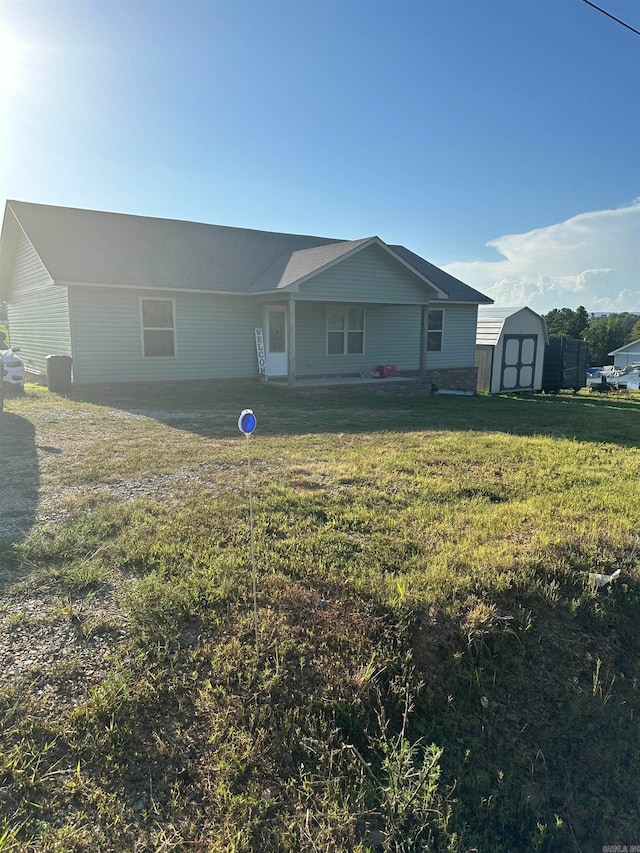 ranch-style house with a storage shed and a front yard