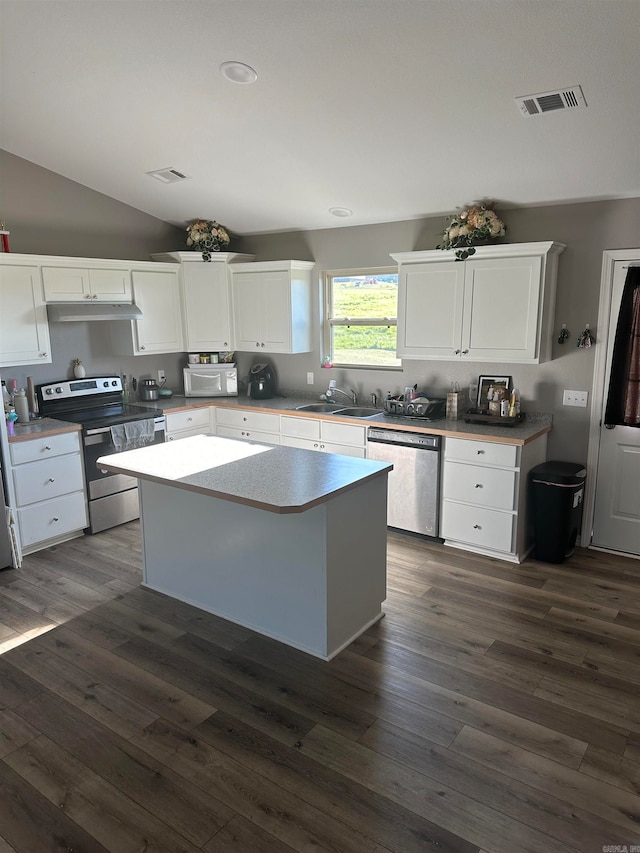 kitchen featuring appliances with stainless steel finishes, a kitchen island, dark hardwood / wood-style flooring, and white cabinets