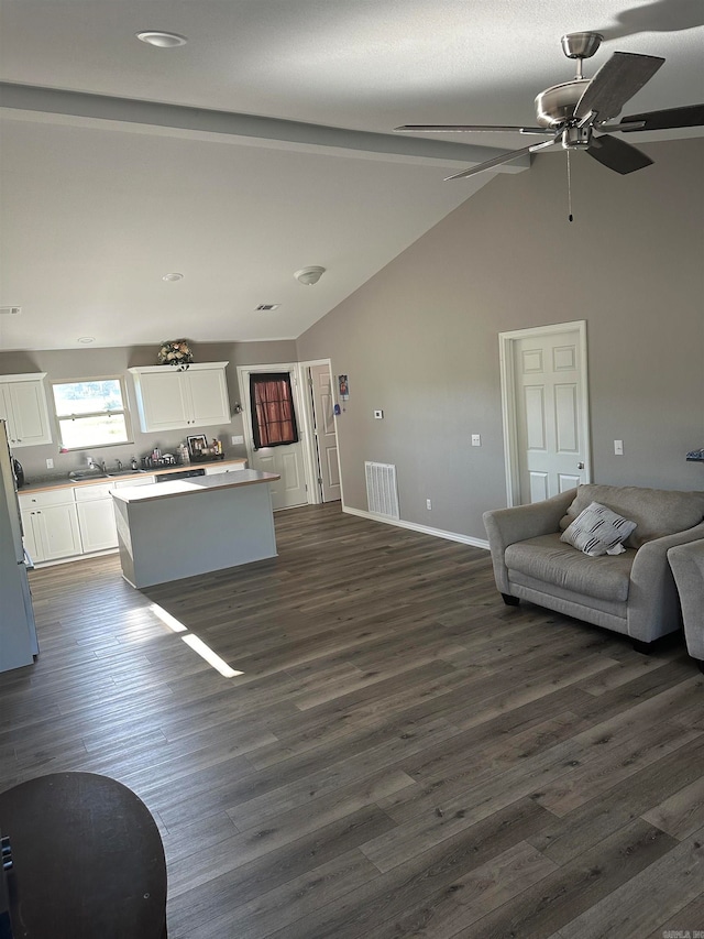 unfurnished living room with sink, beamed ceiling, high vaulted ceiling, dark wood-type flooring, and ceiling fan