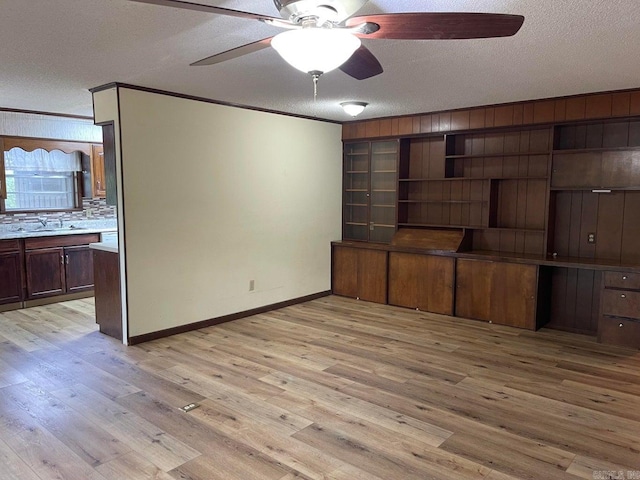 unfurnished living room featuring ceiling fan, a textured ceiling, and light hardwood / wood-style flooring