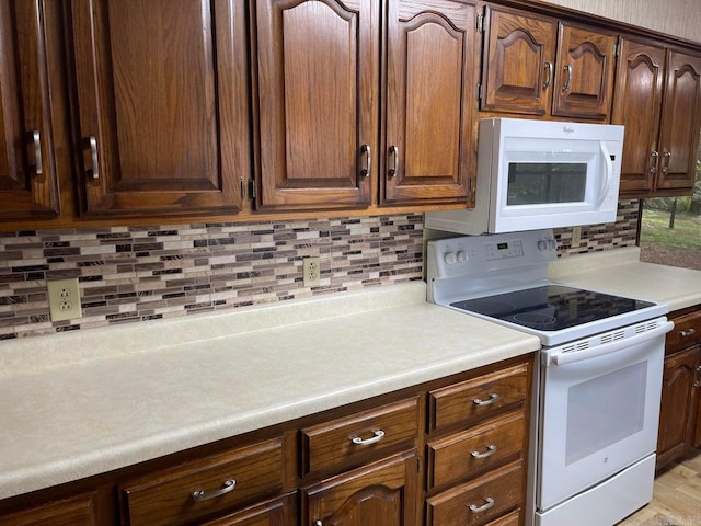 kitchen with tasteful backsplash and white appliances