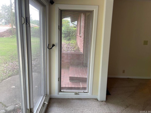 doorway to outside featuring carpet flooring