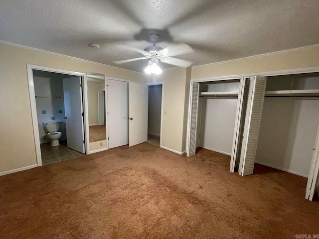 unfurnished bedroom with light tile patterned floors, two closets, and connected bathroom