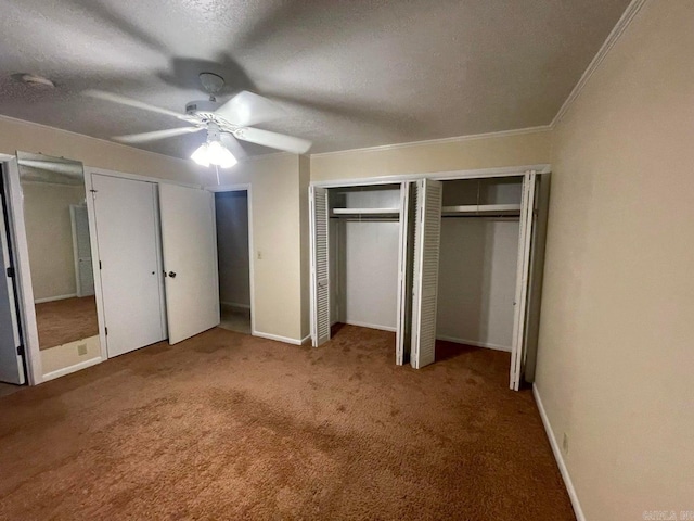 unfurnished bedroom with ceiling fan, two closets, and carpet