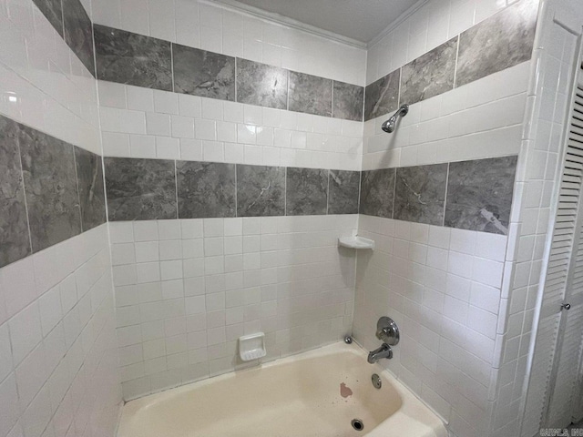 bathroom featuring tiled shower / bath combo and tile walls