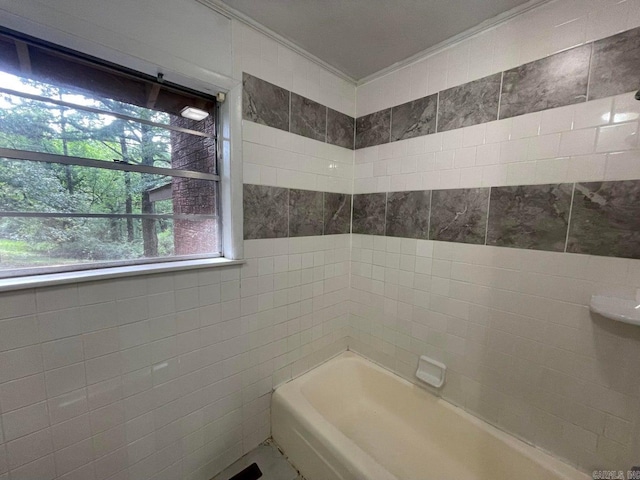 bathroom featuring tile walls and tiled shower / bath