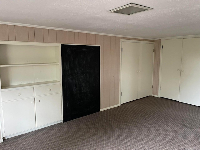 unfurnished bedroom with a textured ceiling and carpet floors