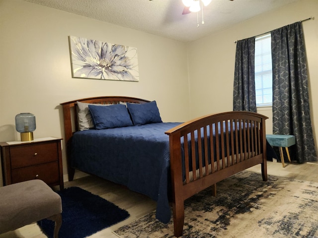 bedroom featuring ceiling fan, a textured ceiling, and wood finished floors