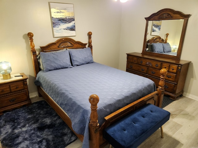 bedroom with baseboards and wood finished floors