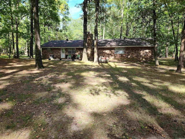 view of front of house featuring a chimney and brick siding