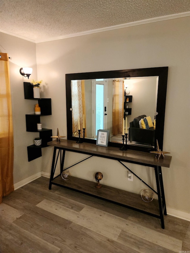 details featuring a textured ceiling, baseboards, wood finished floors, and crown molding