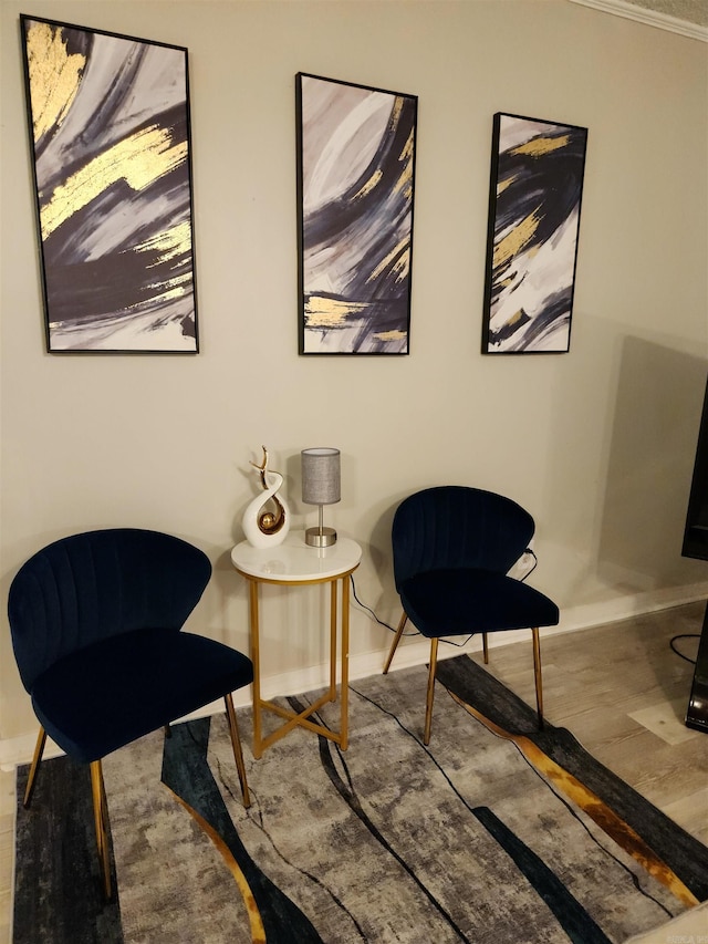 living area with baseboards and wood finished floors